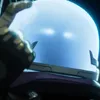 A mysterious looking man with glowing blue eyes in a spiky futuristic chair