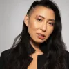 Person wih dark eyes and long dark hair that is buzzed on the right side